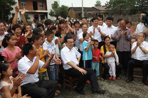 這是7月14日,李克強來到地處大別山區(qū)的紅安縣陳升廟村,看望慰問困難群眾,與大家親切交談。新華社記者 劉衛(wèi)兵 攝
